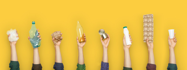 Partial view of group of people holding various types of garbage on yellow background - obrazy, fototapety, plakaty
