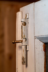 Old wooden door with a metal catch. Antique bolt on a wooden door.