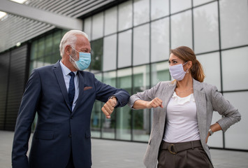 Business people greeting with elbow bump in street