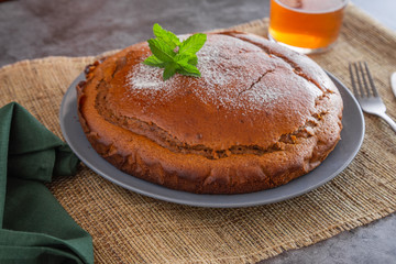 a delicious sponge cake with meant leaves and hot drink