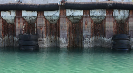 Old mooring wall with old car tires as dampers