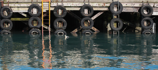 Old mooring wall with old car tires as dampers
