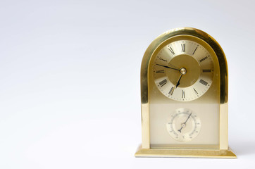 Alarm clock rectangular golden. Vintage home clock. Golden clock on a white background.