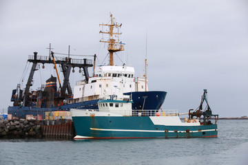 Industrial trawler ships stand moored in port