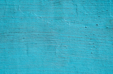 Grunge texture of thick old blue paint on a plastered wall. Colored surface background.