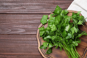 Bunch of fresh green parsley on wooden table, top view. Space for text