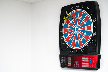Close up of a Dart machine. In the dartboard are dart arrows. Copy Space.