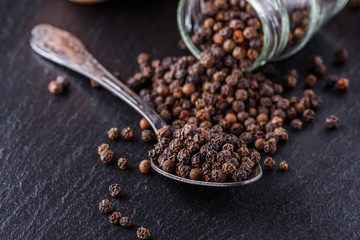 aromatic black pepper on a dark stone background
