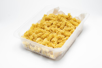 Raw Fusilli macaroni in a plastic box isolated on a white background