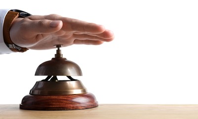 Man ringing hotel service bell at wooden table