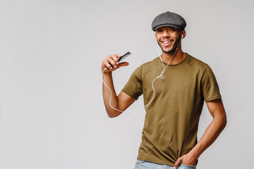 studio shot young african american man listening to music with earphones