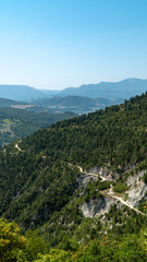 Paesaggio della Gola del Furlo con colline montagne verdi e stradina di ghiaia 