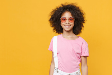 Smiling little african american kid girl 12-13 years old in pink t-shirt eyeglasses isolated on...