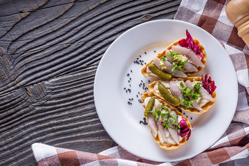 delicious snack tartlets on rustic wooden background