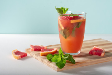 Grapefruit drink with ice and mint on a wooden Board. Grapefruit juice with ice and mint.