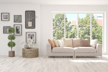 White living room with sofa and summer landscape in window. Scandinavian interior design. 3D illustration