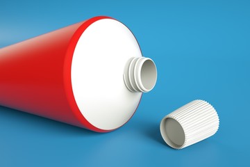 Open toothpaste with cap on blue background