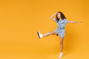 Full length portrait of cheerful young african american woman girl in denim clothes isolated on...
