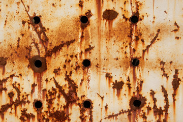 Texture of a rusty metal surface with holes, closeup