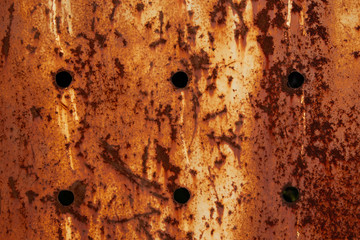 Texture of a rusty metal surface with holes, closeup