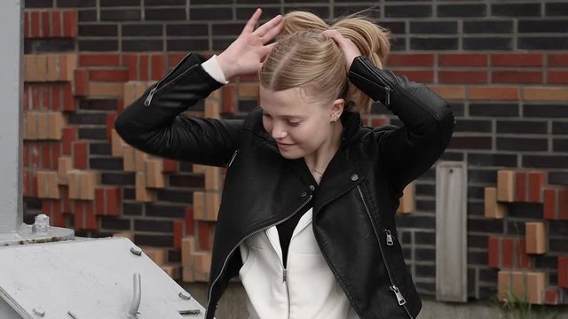 Ein attraktives M&auml;dchen bindet ihre hellen kurzen Haaren, macht einen Pferdeschwanz