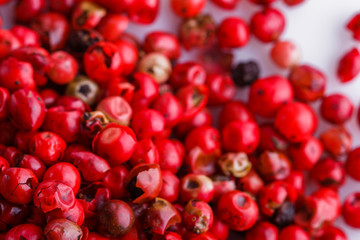 fragrant pink peppercorns on white acrylic background