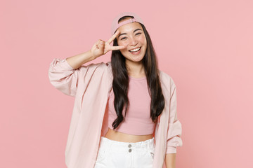 Cheerful young asian woman girl in casual clothes cap posing isolated on pastel pink background...