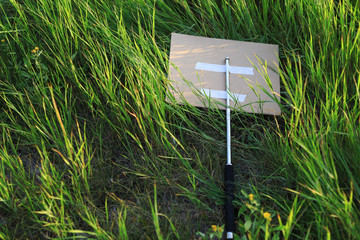 Metal periscope baton of protest activists thrown in bushes or tall grass.