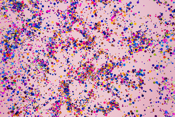 Colorful sparkles on trendy pink pastel background for your creative projects and design. Festive celebration concept. Selective focus