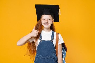 Young redhead school teen girl 12-13 years old in white t-shirt denim uniform graduation cap...