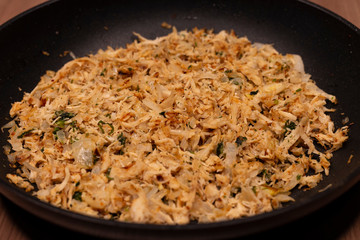 Shredded chicken prepared in a pan with spices and onions