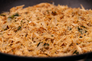 Shredded chicken prepared in a pan with spices and onions