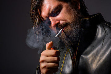 Fototapeta premium Smoking man. Bearded man smoking cigarette. Cigarette smoke. Tobacco. Bearded man with cigarette. Man smoke the cigarette.