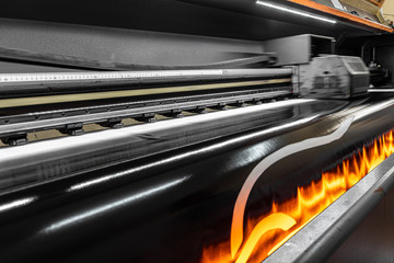 Drying the prints by heating. Printing machine that dries the print with its heated fans. Large format digital printing machine and moving print head. 