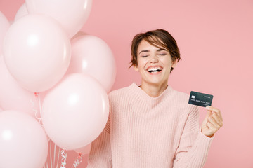 Laughing young brunette woman girl in knitted casual sweater posing isolated on pastel pink...