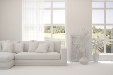 White living room with sofa and summer landscape in window. Scandinavian interior design. 3D illustration