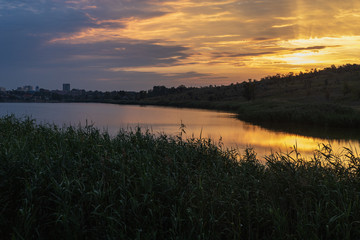 Sunrise or sunset over small lake. Contrast sunlight
