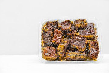 honeycomb pieces with bees wax in a container. apiary production. farmer to market concept. healthy meal plan. local markets and direct purchase.