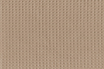 Grunge texture of natural beige cotton fabric in a small cage. Beautiful simple background of natural fabric.