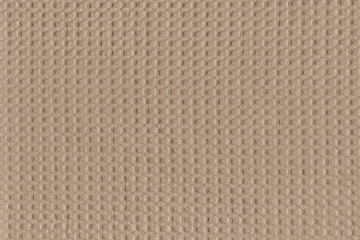 Fototapeta premium Grunge texture of natural beige cotton fabric in a small cage. Beautiful simple background of natural fabric.