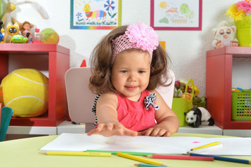 Fototapeta premium Portrait of cute little baby girl drawing