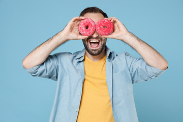 Cheerful funny young bearded man guy 20s wearing casual clothes posing holding in hands covering...