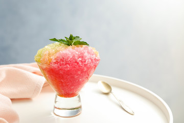 Shaving ice in glass dessert bowl on white table, closeup