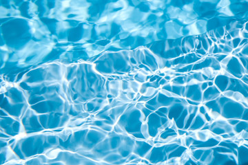 Texture of blue water in swimming pool as background, closeup