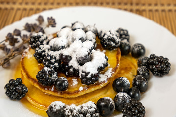 Pancakes served with black currant and blackberry. Dessert and breakfast concept