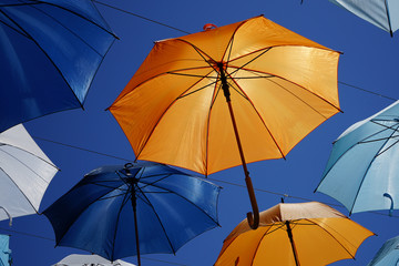 open umbrellas as a sun canopy on a city street on a clear sunny day in summer