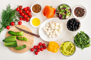  ingredients for summer vegetable salad with feta cheese and mustard on light concrete background.