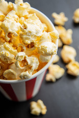 Sweet tasty popcorn in striped paper cup.