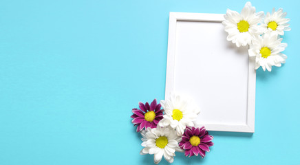 square white frame with white and red flowers on blue background. View top. Messege or invitation card, nature concept. flower layut. copy space for text