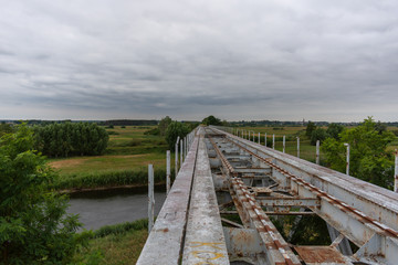 Fototapeta na wymiar Abandoned, high railway bridge over the river